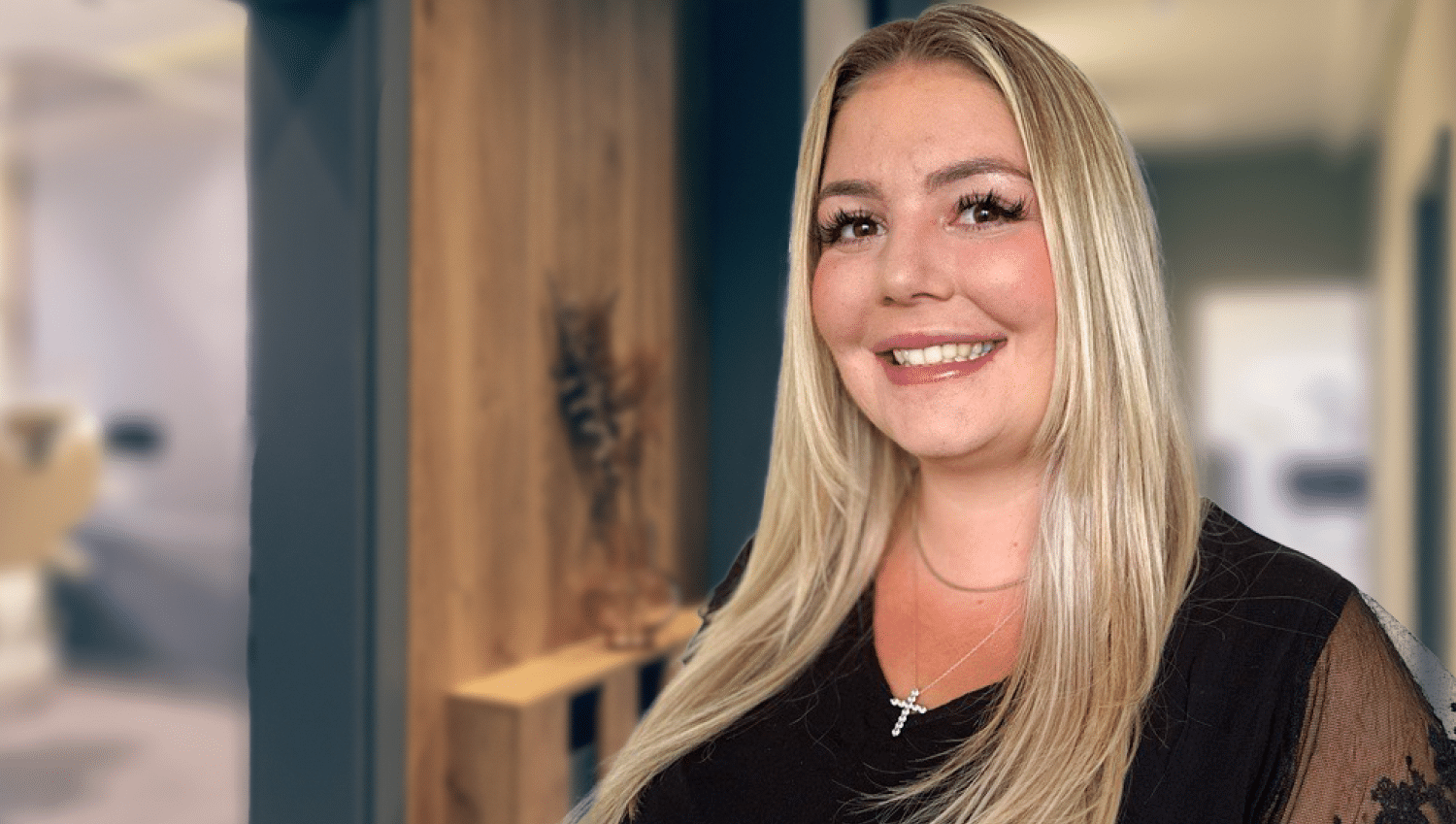 Blonde female, Elizabeth Bologna headshot with a black dressy top.