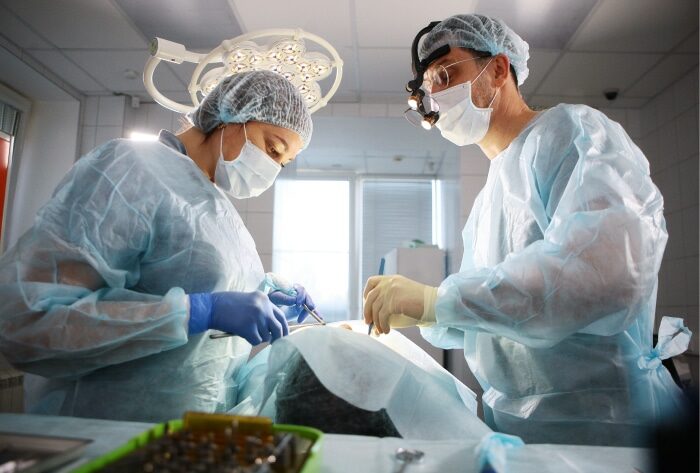 Oral Surgeon working on a patent with the help of a dental technician