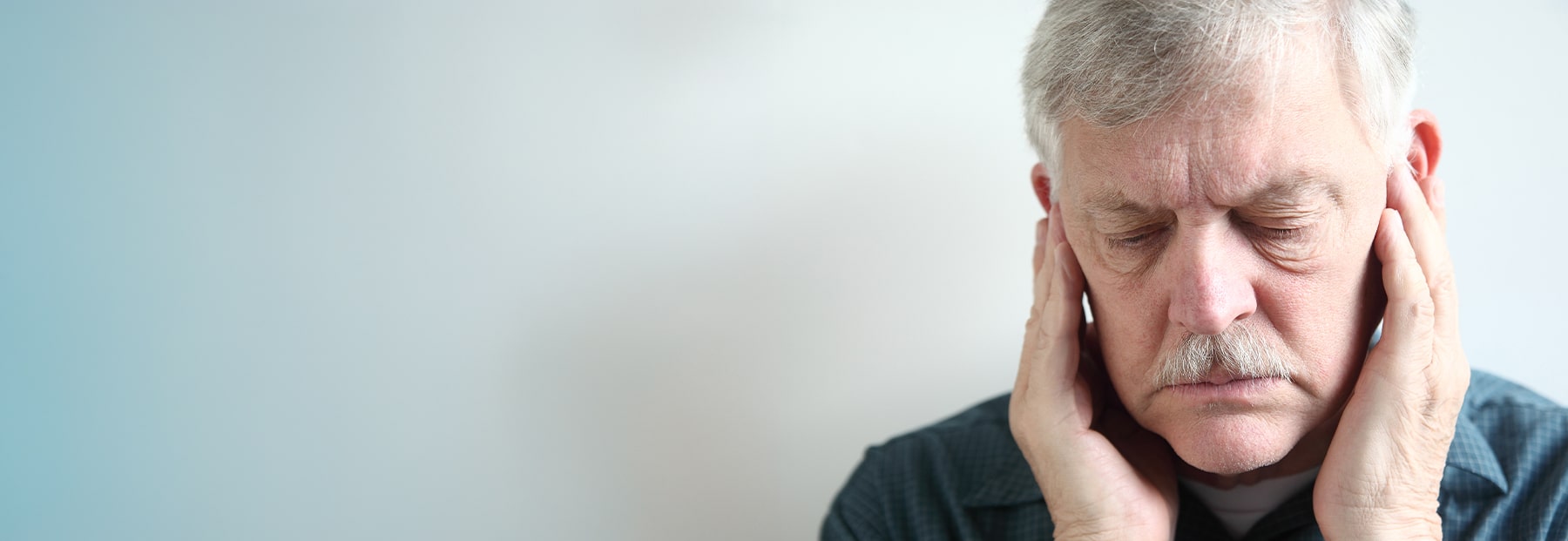 Older person rubbing his face near his upper jaw displaying pain.