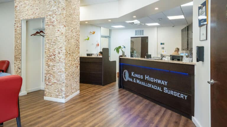 Interior view of Kings Highway oral and maxillofacial surgery office with brown front desk, and wooden floors.